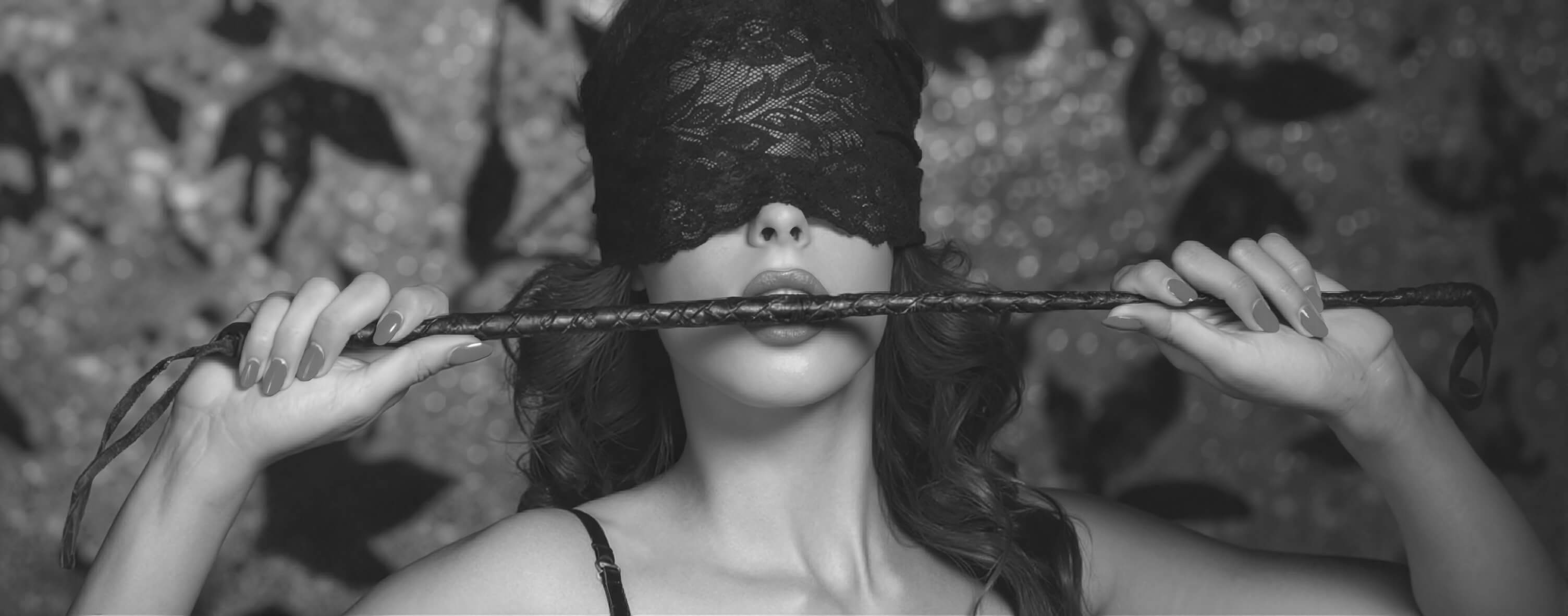 Sensual scene with lace blindfold, BDSM whip, striking red lips, and playful finger bite, featuring bold erotic accessories for a provocative and seductive visual style.