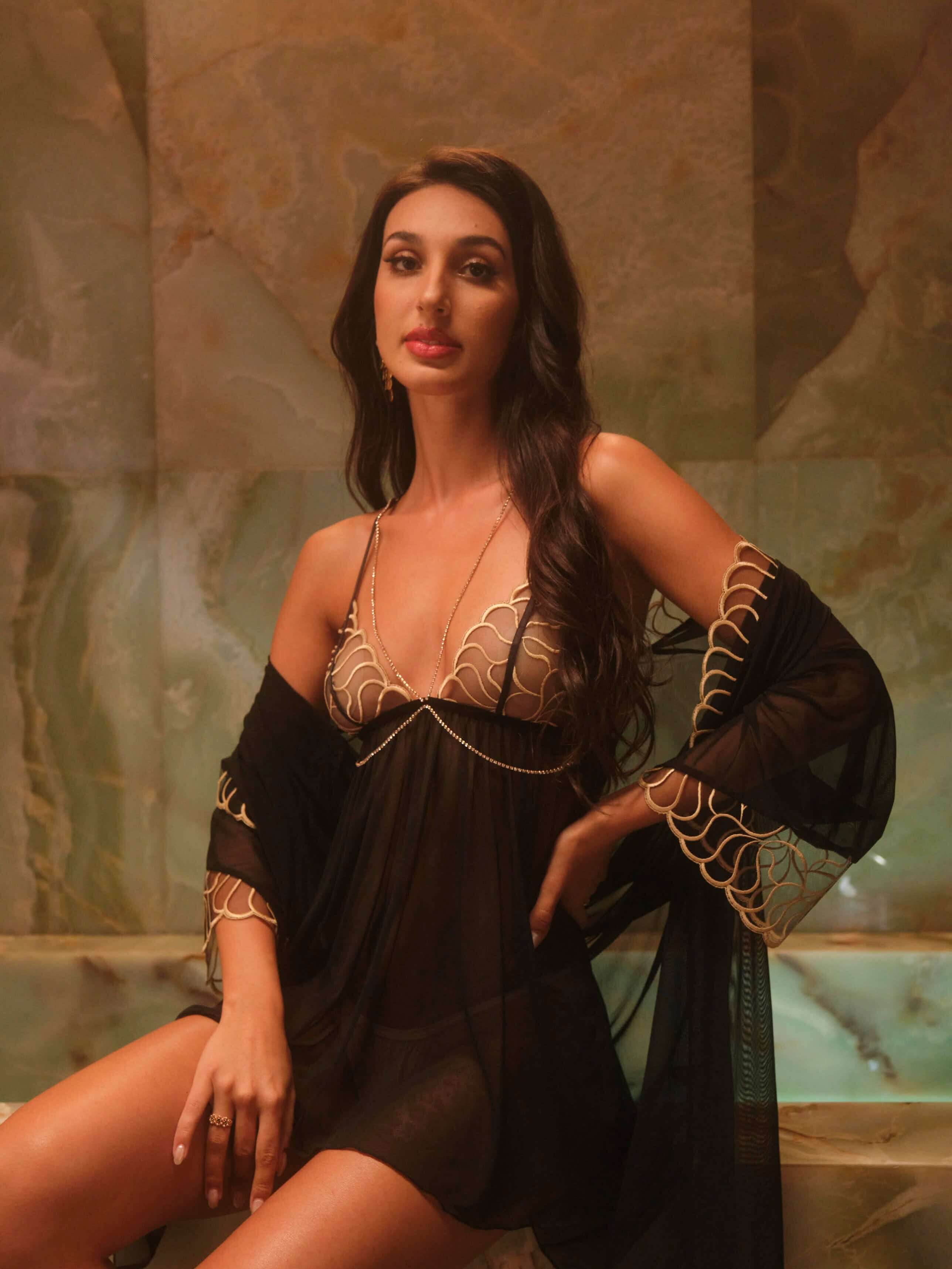 Elegant black lace dress featuring see-through sleeves and delicate gold embroidery for a luxury look